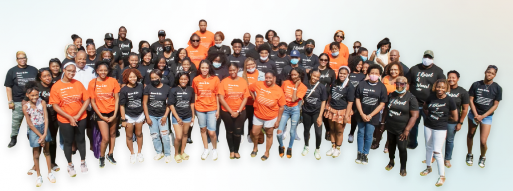 A group of people wearing black and orange T-shirts